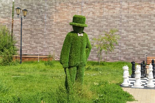 Figure man artificial grass, topiary. Selective focus, close-up. Copy space