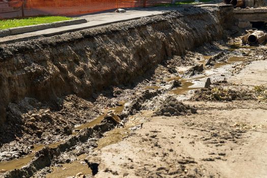 Asphalt road collapsed with cracks and pits, replacing the underground water supply in the city. Selective focus
