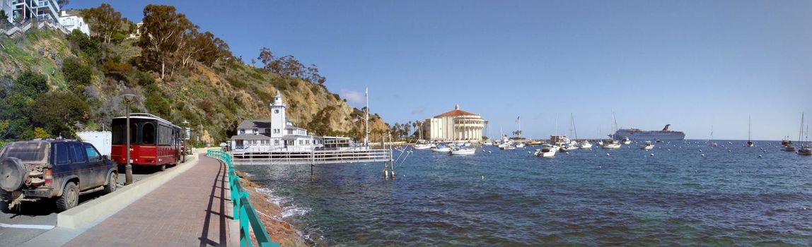 Catalina - March 10, 2009:  Car and Trolley parked along road in Avalon Bay with Carnival Cruise ship and other boats in the water.   Catalina Island is located off the coast of California.