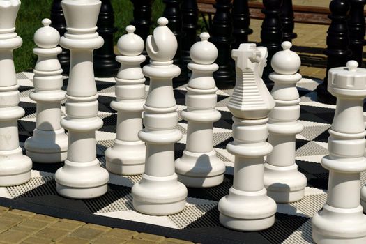 Big pieces and giant chess board of street chess in the park. Selective focus