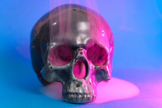 Old Skull. Select focus, blue background. Straw voodoo dolls. Musical, terrible smoke of evil. Halloween holiday concept. Selective focus