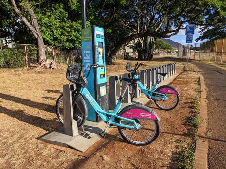 Honolulu - August 7, 2021: Two Biki Bikeshare bicycles parked along bike path in Kapahulu.  Biki is Honolulu’s new transportation system, brought to you by Bikeshare Hawaii. Launched in late June 2017, Biki has 1,000 bikes at 100 conveniently located self-service “Biki Stops” from Chinatown to Diamond Head.