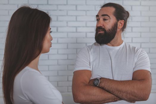 Bearded mature man talking to his female colleague at the office. Businesspeople discussing work together. Male entrepreneur chatting to co-worker
