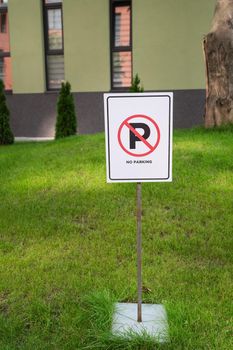 No parking sign board on green lawn stand near the house