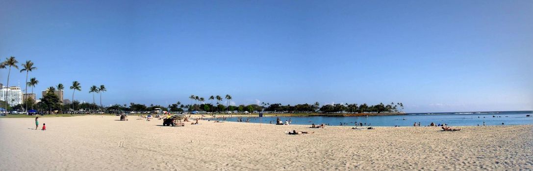 Honolulu - June 4, 2009:  Ala Moana Beach with people hanging out and swimming in the water on a beautiful day.  Panoramic