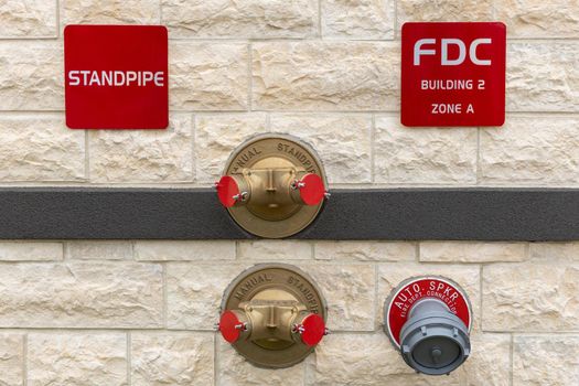 Manual standpipes, automatic sprinkler fire department connection, red signs with inscriptions on the wall of building