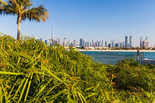Dubai, UAE - 02.27.2021 Dubai public beach with city skyline on background.