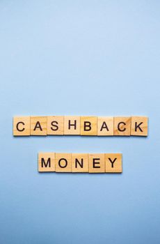 Finance concept. On a blue surface, wooden cubes with the inscription cashback money. Vertical photo