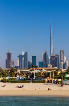 Dubai, UAE - 02.27.2021 Dubai public beach with city skyline on background.