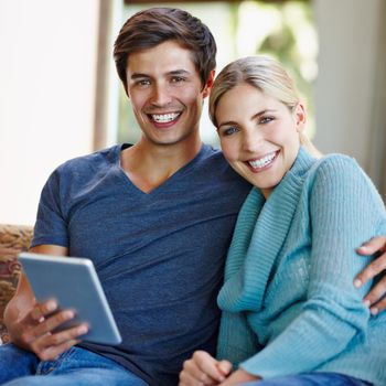 Wireless bliss. a happy young couple using a digital tablet together on the sofa at home