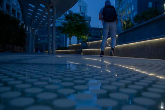 Teenager running in the business district of a Dubai city, UAE. Outdoors