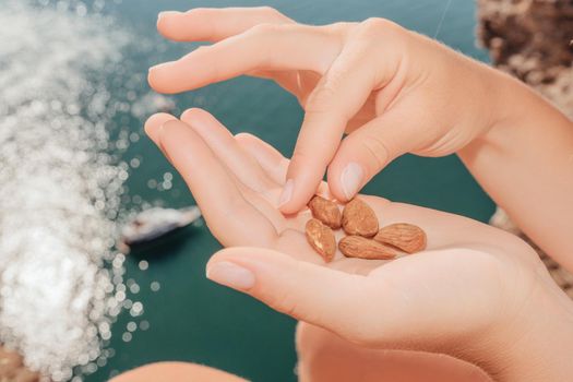 Unrecognizable caucasian woman eating young milky almond nuts. Healthy vegan food