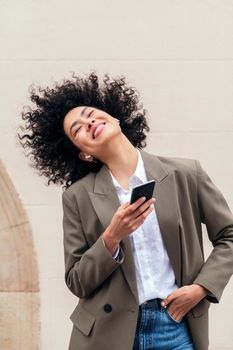 happy woman with wireless earphones listening music and dancing with her phone, concept of youth and technology, copy space for text