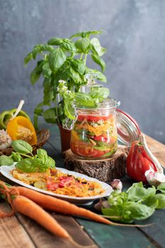 orange salad of paprika,tomatoes, carrots and basil for harvesting for the winter in a jar. High quality photo