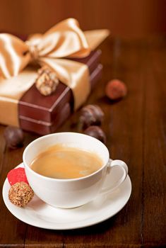 a cup of coffee and candy on vintage wooden background