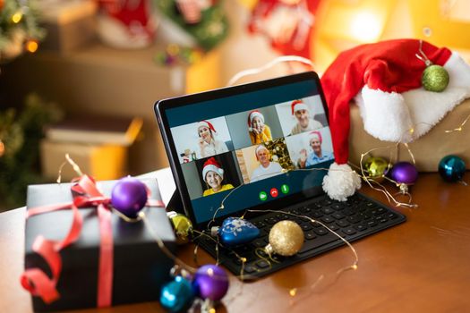 Big family singing christmas song at tablet camera during online video call. Smiling parents and children. Joyful family congratulating relatives with happy new year online.