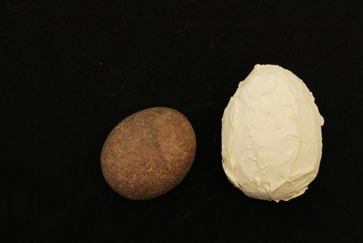 Large and small decorative stone eggs on a dark background.