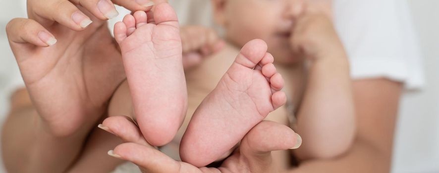 Parent holding in the hands feet of newborn baby.