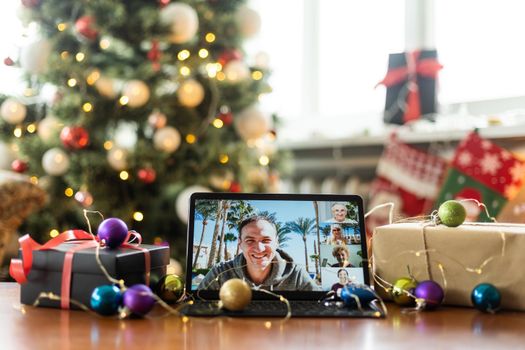 Big family singing christmas song at tablet camera during online video call. Smiling parents and children. Joyful family congratulating relatives with happy new year online.