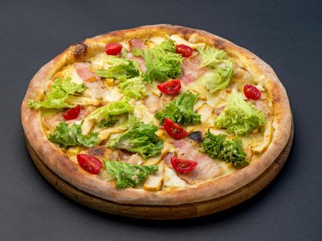 Traditional Italian pizza, vegetables, ingredients on a dark background.