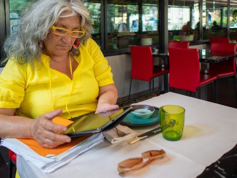 mature woman customer ordering food at restaurant using digital tablet