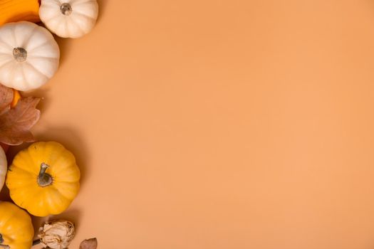 Autumn flat lay composition with pumpkins and fallen leaves and sweater with space for text.