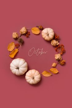 October text and autumn flat lay wreath of pumpkin, leaves and flowers with berries top view. Vertical format