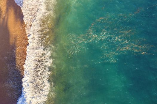 top view of beautiful beach with turquoise sea water and wave foam, copy space for text