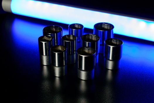 Socket wrench heads made of chrome vanadium on the dark background in a neon blue light. . High quality photo