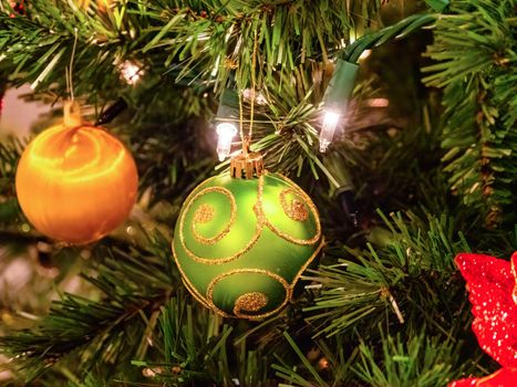 Christmas tree decorated with lights and baubles. Closeup look of decorative ball