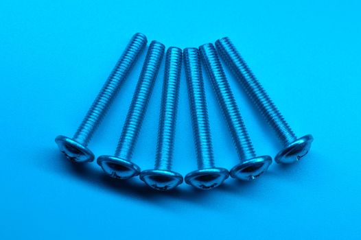 Set of six screws on a light blue background. Macro photo. Background picture. High quality photo