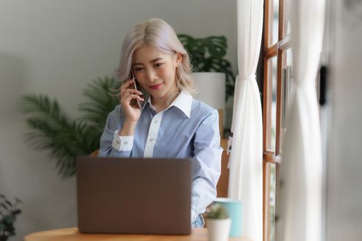 Woman calling with friend by mobile phone at home.