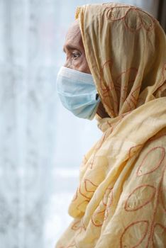 portrait of an old woman wearing a surgical mask,