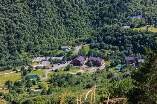 View from the height of the mountains to the picturesque landscape of the house of the lake and the river