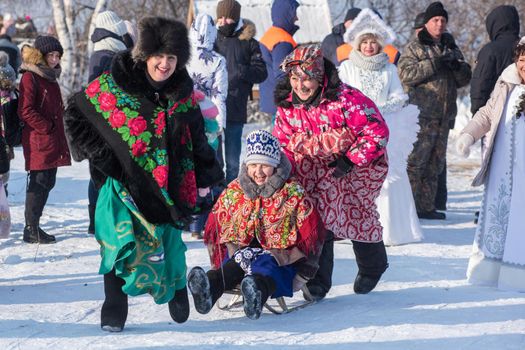 Altaisky krai - DEMEBER 2, 2018: RussiaFunny Elderly women sledding. Altaiskaya zimovka holiday - the first day of winter on December 2, 2018 in Altai, Siberia, Russia