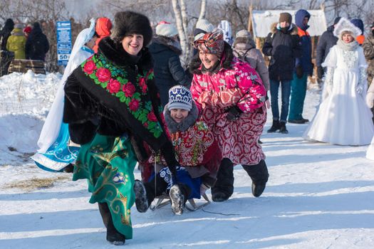 Altaisky krai - DEMEBER 2, 2018: RussiaFunny Elderly women sledding. Altaiskaya zimovka holiday - the first day of winter on December 2, 2018 in Altai, Siberia, Russia