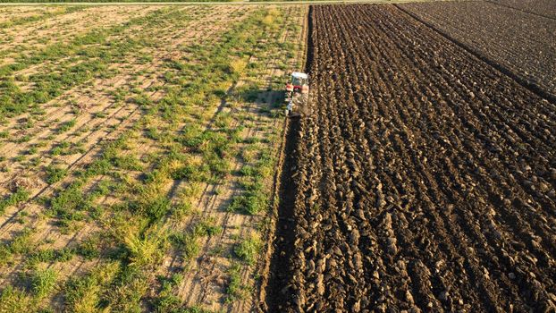 Aerial view with drone of tractor plowing the land in the countryside.