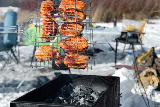 Winter barbecue party outdoors, grill steak meat over hot coals in BBQ at campsite cookout, close up view, camping mood