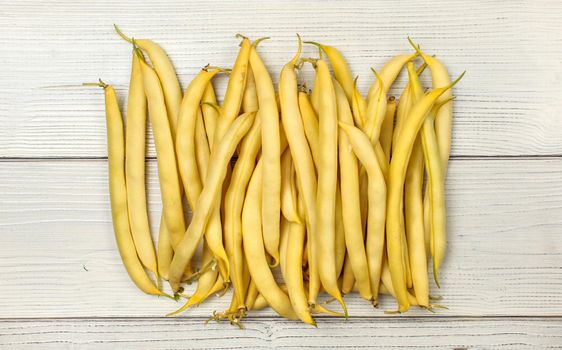 Yellow string (wax) beans on white boards. Tabletop view.
