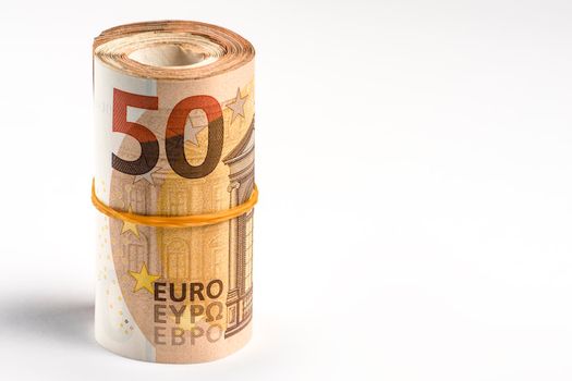 Roll of money. Roll of 50 euro banknotes. Euro banknotes rolled up on a gray background. The concept of financial assistance, real estate purchase, loan or insurance payment