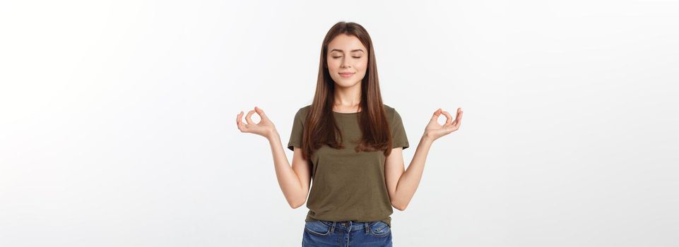 Beautiful young woman in yoga position and meditating isolated over gray background.