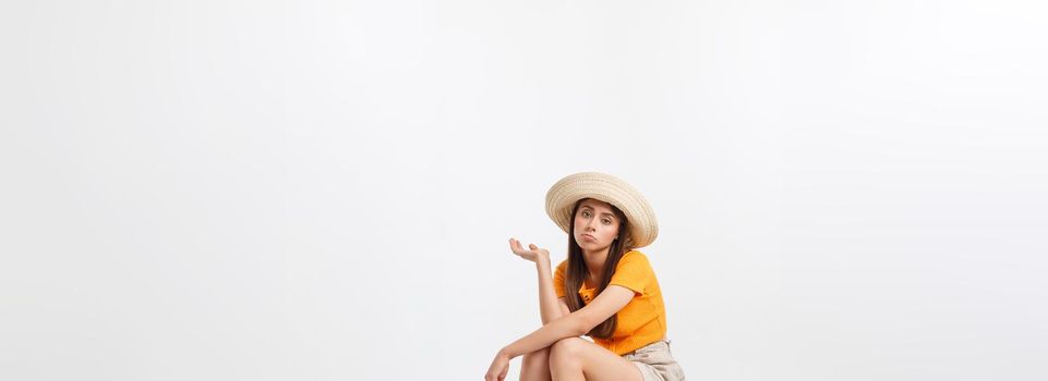 Lifestyle and travel Concept: Young beautiful caucasian woman is sitting on suitecase and waiting for her flight.Isolated over white background.