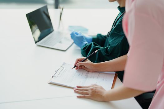 Portrait of Asian doctors and nurses using computers and documents to view patient information to analyze symptoms before treatment