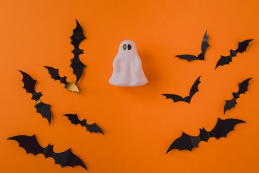 Ghost on the background of bats on an orange background. Place for your text.