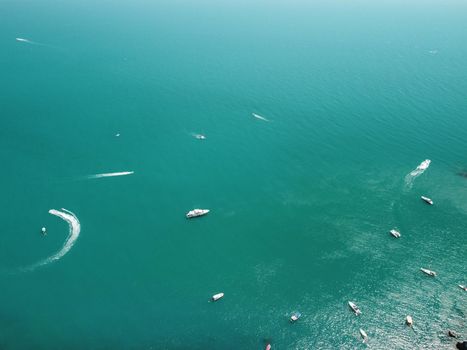 Aerial boat race. Luxury cruise trip. View from above of white boat on deep blue water. Aerial view of rich yacht sailing sea. Motor boat racing wave. Summer journey on luxury ship