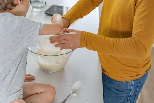 young man making homemade bread with his son in his home kitchen