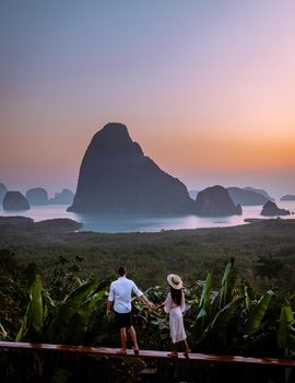 young men and women on vacation in Thailand visiting the bay of Phannga famous for watching the sunrise at Samet Nang She viewpoint. Couple of men and women watching the sunrise at Samet Nang She's viewpoint