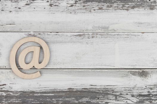 An email sign on a old white wood lies on a vintage wooden table. Concept e-mail message letter. Top view with copy space