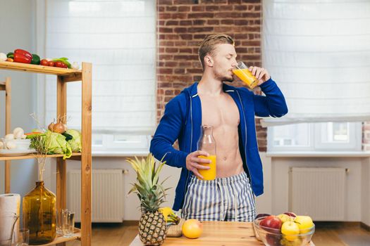 Close up photo Body part young athletic athletic fitness handsome man drinking fresh orange juice from glass in kitchen at home in casual clothing