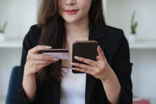 Young person using credit card and laptop computer. Online shopping, e-commerce concept.